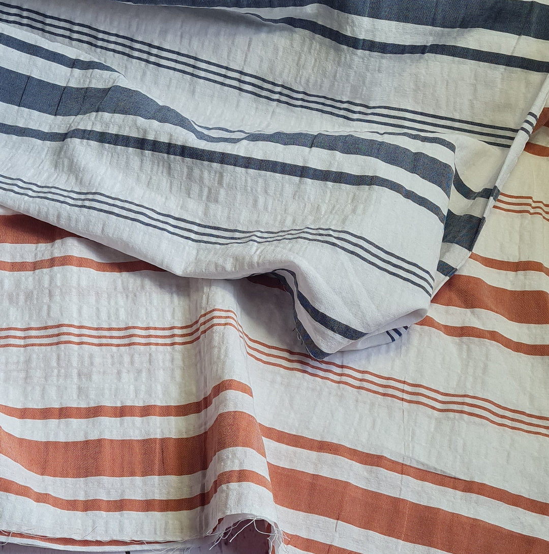 Yarn-dyed horizontal stripe seersucker cotton fabric. Blue/rust by the half metre